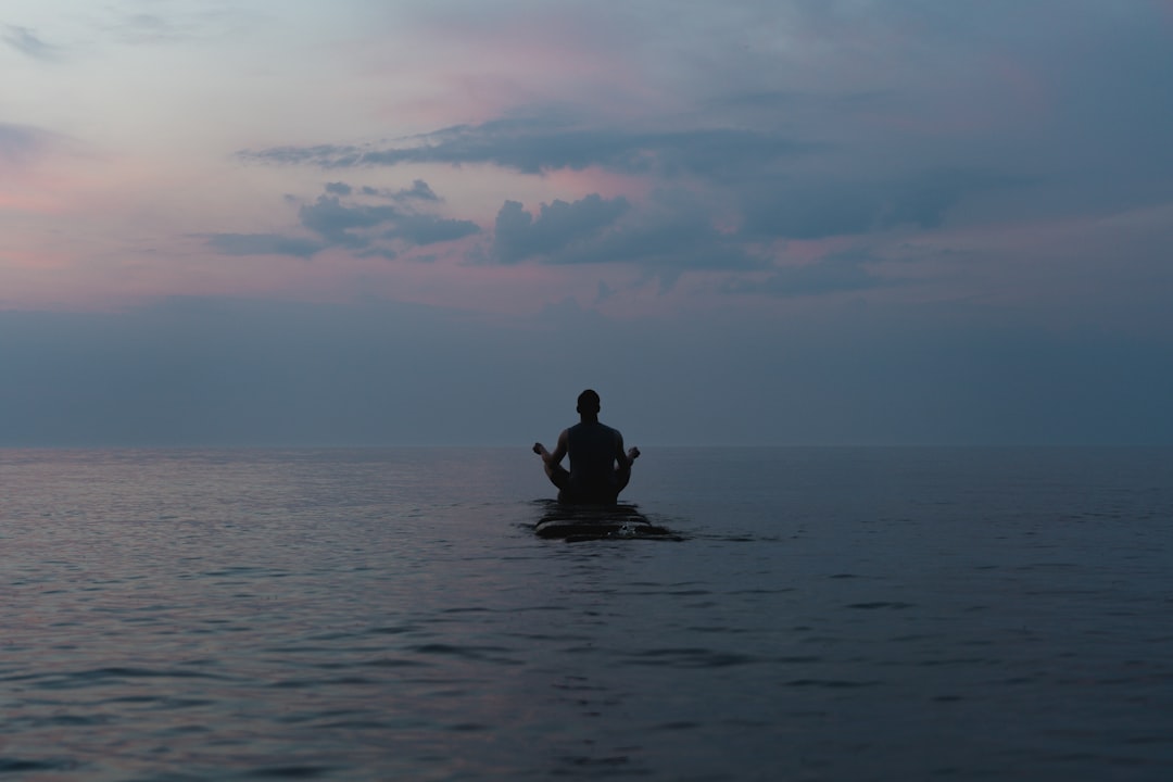 persona meditando en medio del mar para disfrutar de la soledad