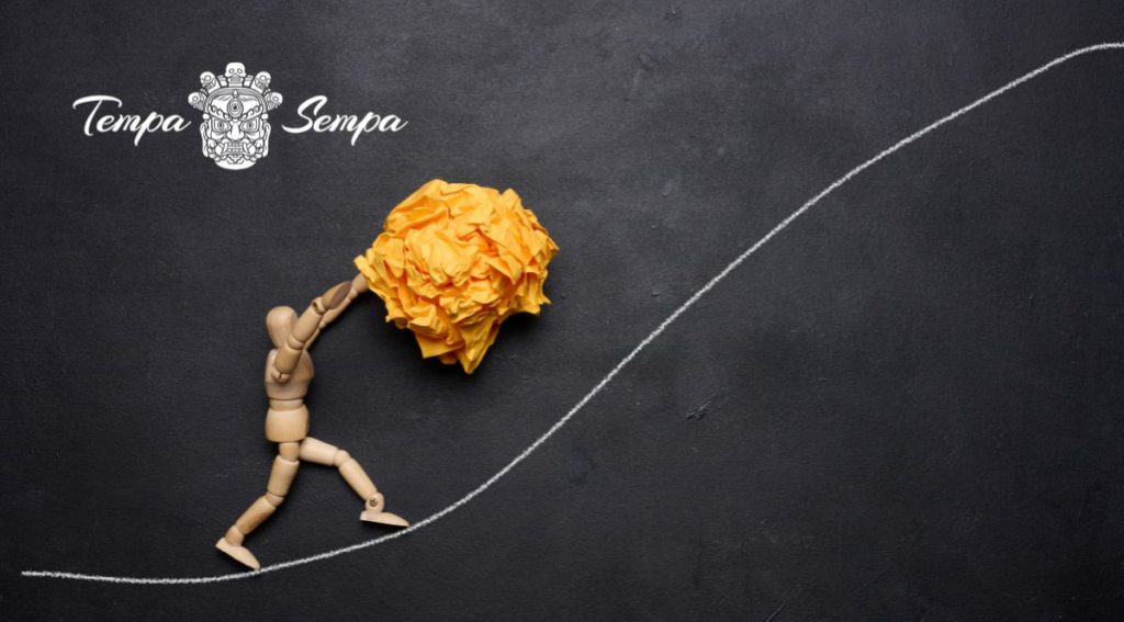 muñeco de madera  mostrando resiliencia al subir un  papel por una cuesta