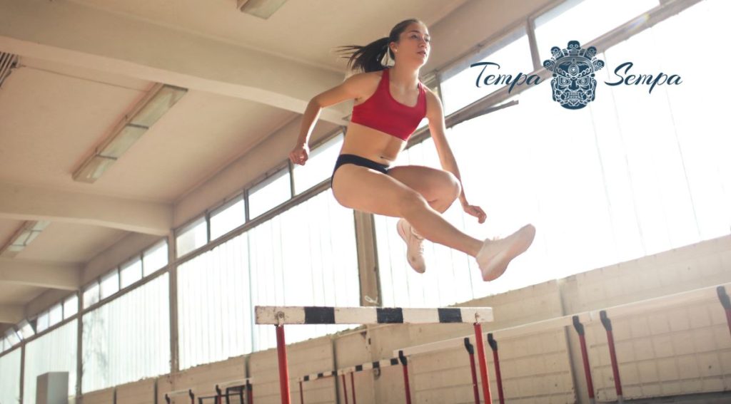 chica saltando una vaya de atletismo