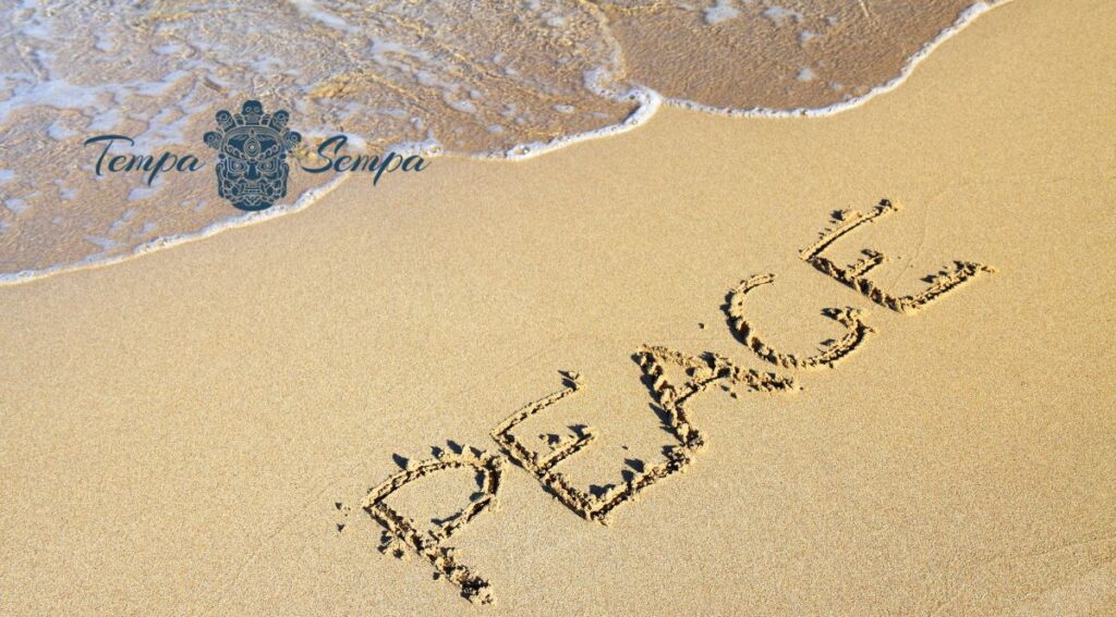 escrito en la arena de la playa en ingles la palabra paz