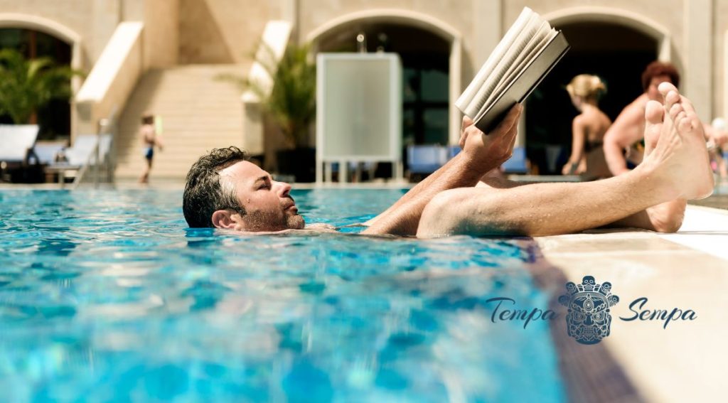 hombre leyendo dentro de una piscina